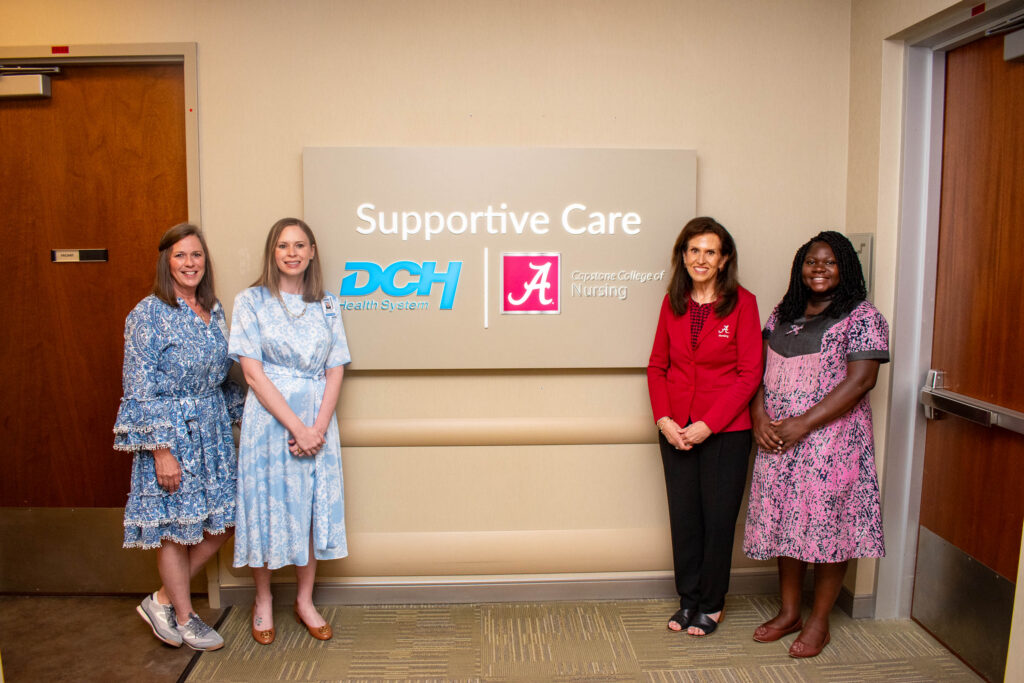 Leaders of DCH and UA College of Nursing pose with Supportive Care signage at Manderson Cancer Center